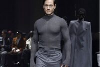 Miliarder teknologi Bryan Johnson mengenakan setelan abu-abu di catwalk Paris Fashion Week.