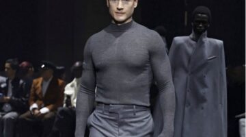 Miliarder teknologi Bryan Johnson mengenakan setelan abu-abu di catwalk Paris Fashion Week.